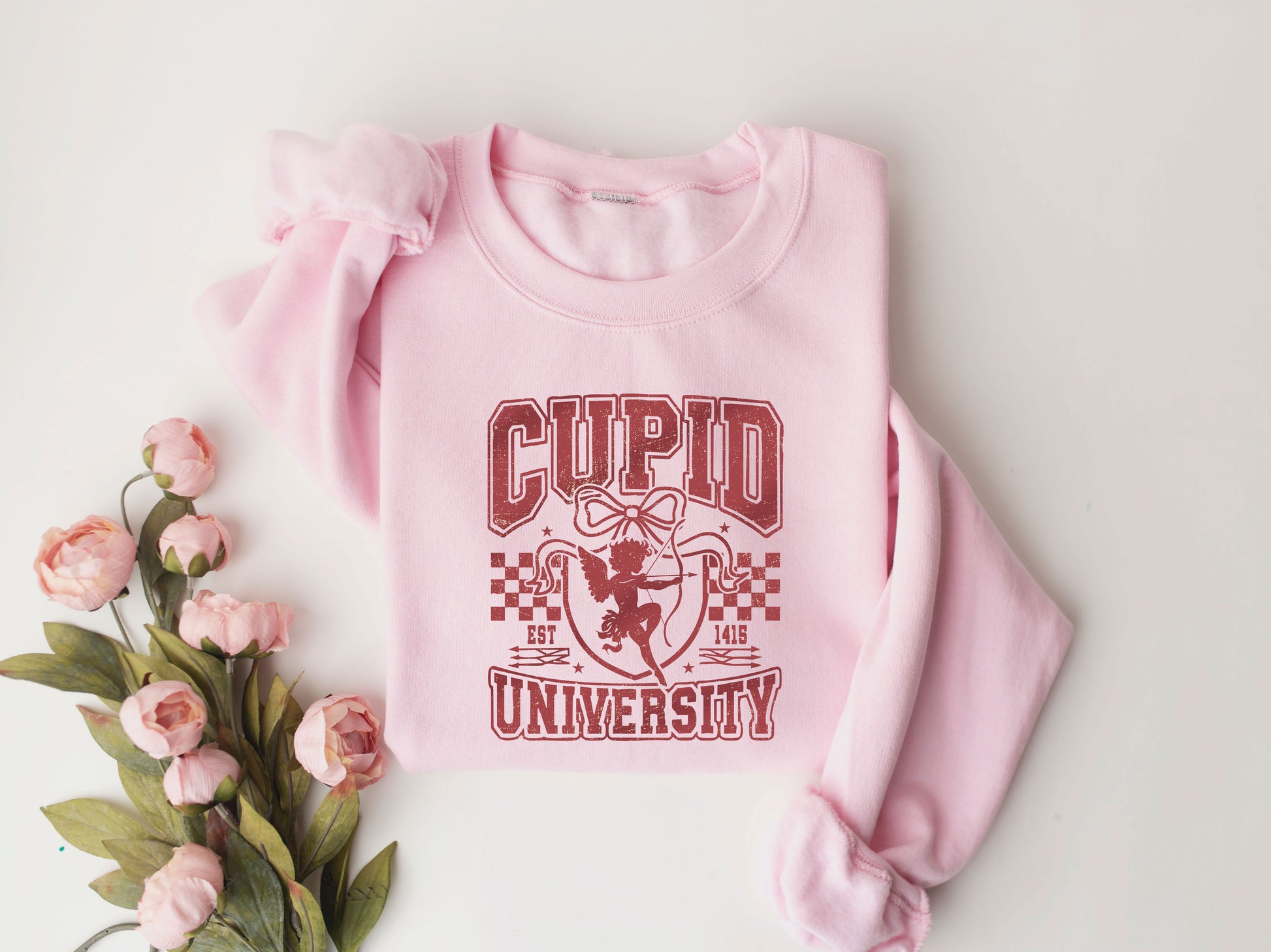 Cupid University Valentine's Day DTF Transfer design on a pink sweatshirt with floral accents.

