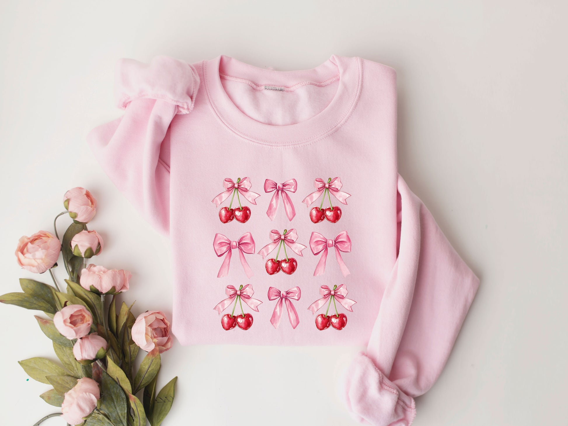 Cherry and bow Valentine's Day DTF Transfer design on a pink sweatshirt with floral accents.

