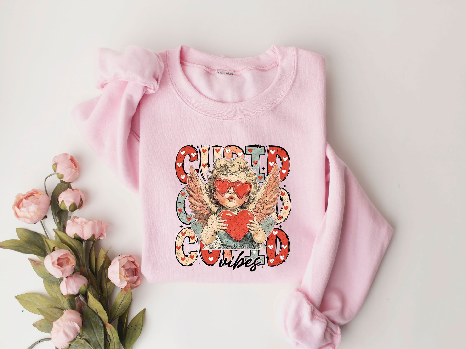 Cupid Vibes Valentine's Day DTF Transfer design on a pink sweatshirt with floral accents.

