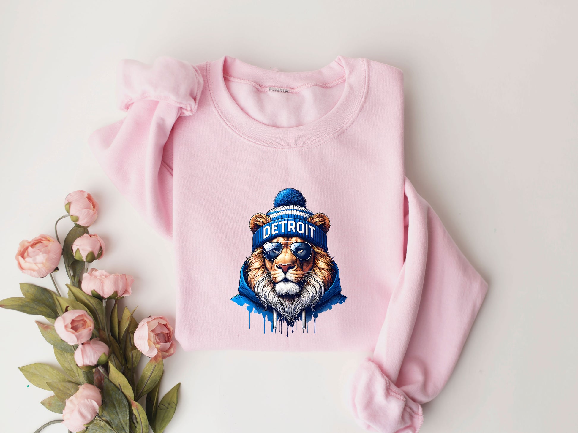 Detroit Lion DTF Transfer design featuring a lion in a beanie and sunglasses on a pink sweatshirt.