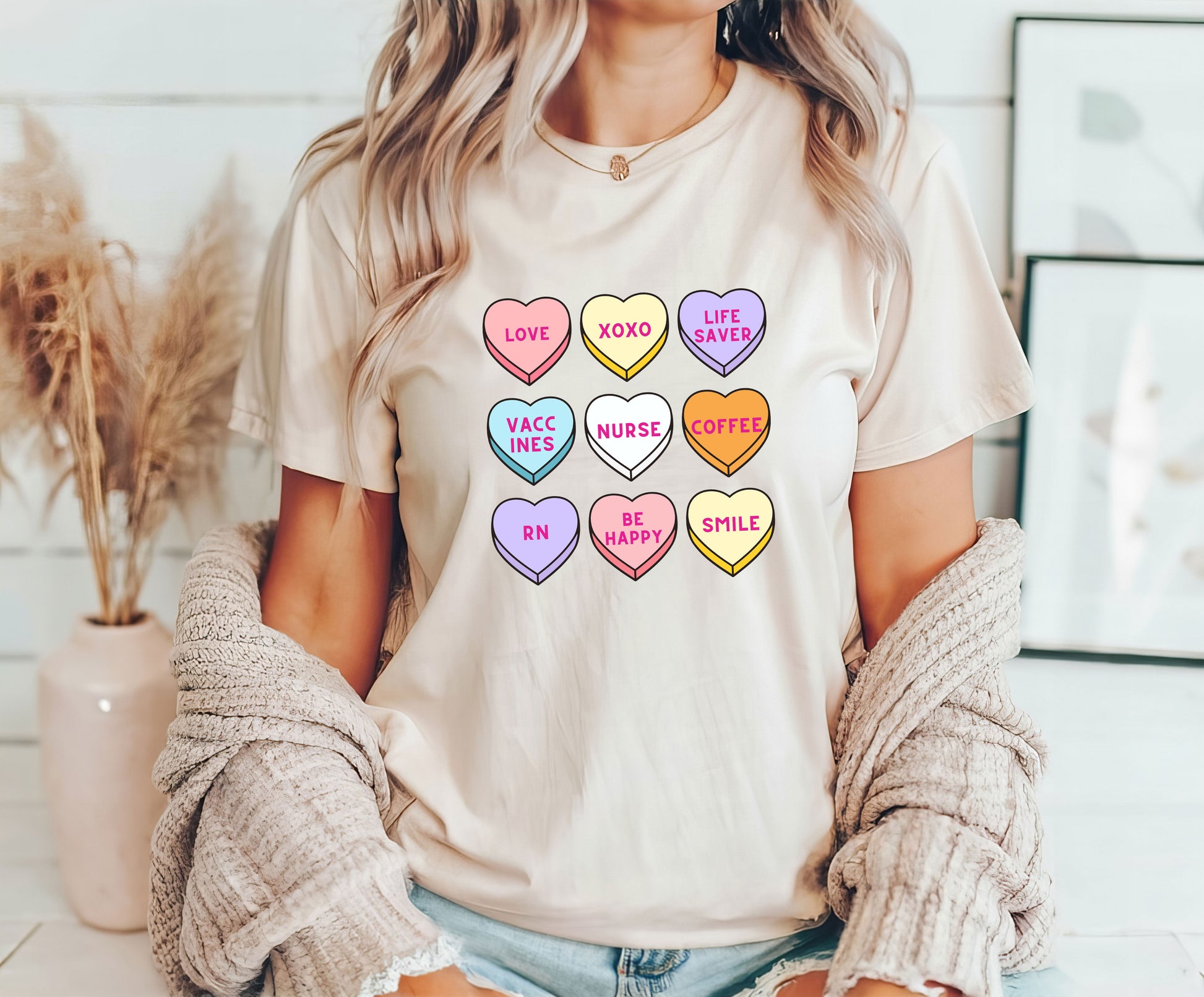 Candy heart nurse DTF transfer design with colorful hearts featuring nurse-related phrases on a beige shirt.