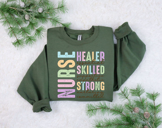 Nurse word art DTF transfer with colorful inspirational words on a green sweatshirt.