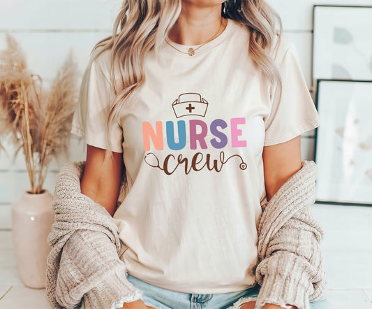 Nurse Crew DTF transfer design on a beige t-shirt with pastel colors and a stethoscope.