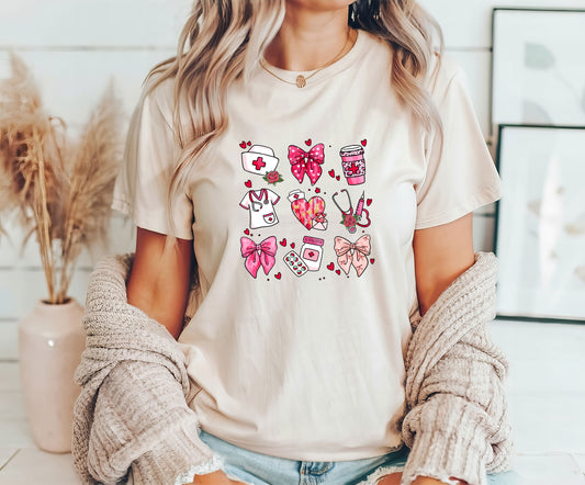 Nurse Icons and Bows DTF Transfer on a beige t-shirt featuring nursing symbols, hearts, and pink bows.