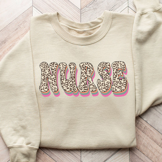 Leopard Print Nurse DTF Transfer on a beige sweatshirt with bold lettering and pink shadow accents.