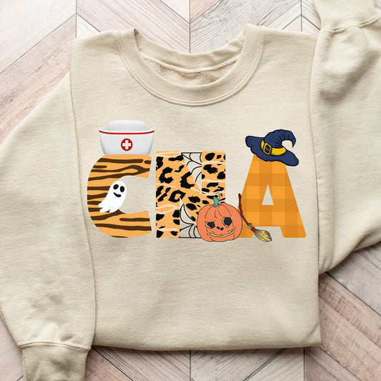 Halloween CNA DTF Transfer on a beige sweatshirt with ghost, pumpkin, witch hat, and animal print details.